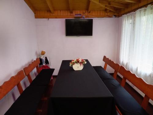 a conference room with a black table and chairs and a television at Holiday guest house KEMO in Sapareva Banya