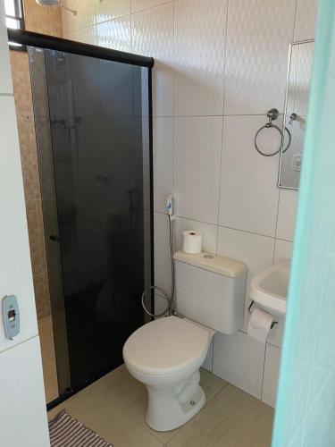 a small bathroom with a toilet and a shower at Flat no Caribe in Maragogi