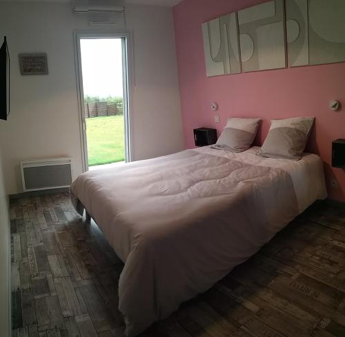 een groot bed in een slaapkamer met een roze muur bij Gite de la Bultiere 4 etoiles ouvert a l'annee entre Montaigu et les Herbiers in Chavagnes-en-Paillers