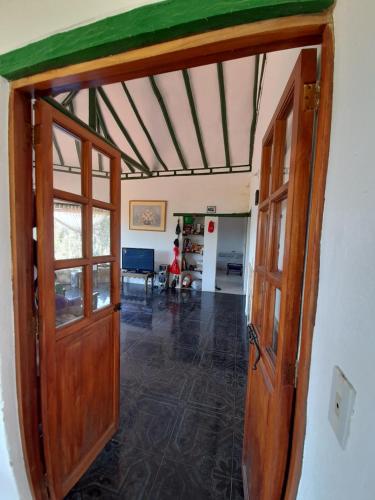 CABAÑA VILLA LUISA de LEYVA في فيلا دي ليفا: باب مفتوح لغرفة المعيشة ذات السقف