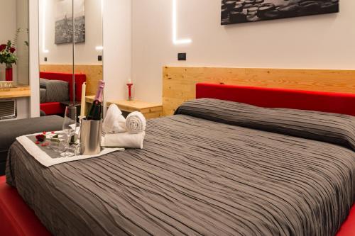 ein Hotelzimmer mit einem Bett und einer Flasche Wein in der Unterkunft B&B Le Nazioni in Lido delle Nazioni