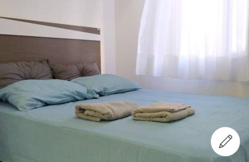 a bed with two towels on top of it at Quarto sala completo in Brasilia