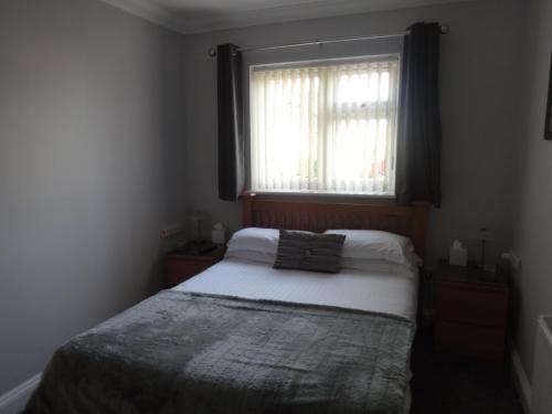 a small bedroom with a bed and a window at Autumn House in Cambridge