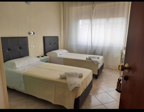 1 Schlafzimmer mit 2 Betten und einem Fenster in der Unterkunft R&B Hotel in Alfonsine