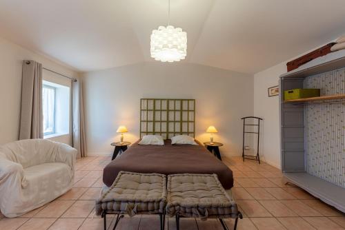 1 dormitorio con 1 cama grande y 1 silla en La maison de Charlotte-Le gite-Futuroscope, en Amberre