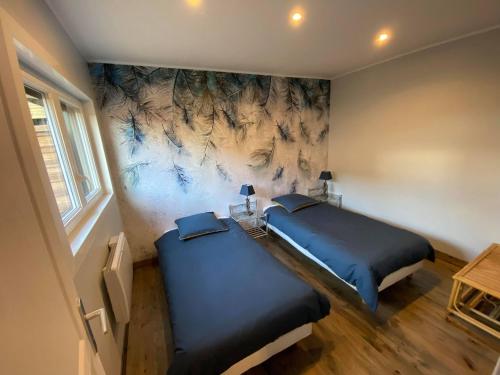 ein Schlafzimmer mit 2 Betten und einem Wandgemälde in der Unterkunft Studio 41 in Eppeville