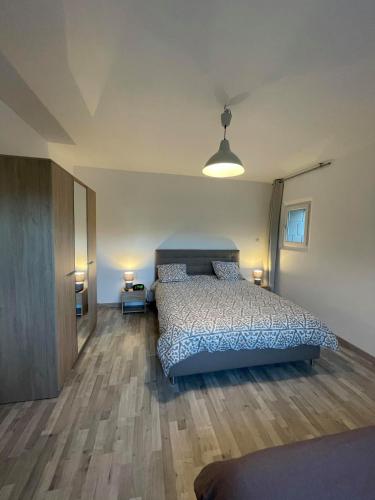 une chambre avec un lit avec une couette bleue dans l'établissement CHEZ Xavier, à Les Assions