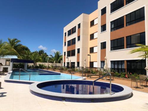 una piscina frente a un edificio en Apartamento em Guarajuba, BAHIA 2 Tudo Novinho e Finamente Decorado, en Camaçari