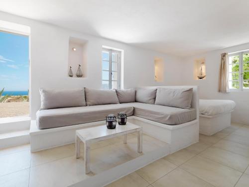 a white living room with a couch and a table at The Windmill Kimolos in Kimolos