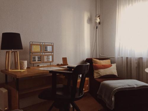 Habitación con escritorio y silla con lámpara. en AJ - tér apartman miskolc en Miskolc