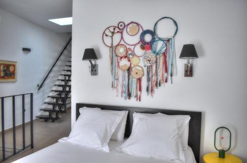 a bedroom with a bed with white pillows and a painting on the wall at Home Apartments Jerez in Jerez de la Frontera