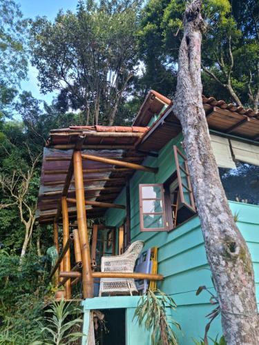 a green house with a tree at Chales Bamboo Jungle in Petrópolis