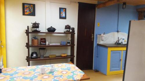 a room with a kitchen with a table and a counter at Chales Bamboo Jungle in Petrópolis