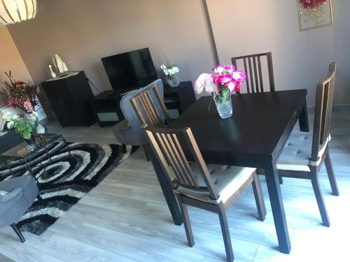 a black table with chairs and a vase of flowers on it at Near DISNEYLAND. Your location to enjoy holidays. in Bussy-Saint-Georges