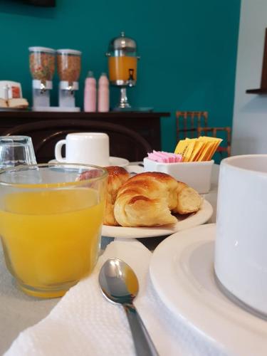 a table with a plate of pastries and a glass of orange juice at Hotel Rincón de Playa in Miramar