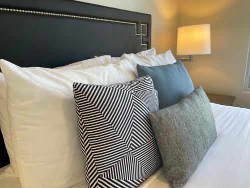 a bed with white pillows and a black headboard at Riverfront Park Travel Apartments in Spokane
