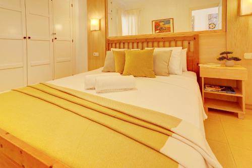 a bedroom with a large white bed with yellow pillows at Orlando - Sea View Apartment in Costa Adeje in Adeje