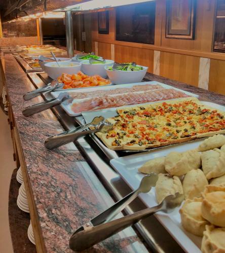 a buffet with pizzas and other food on a table at Hotel Amoros in Cala Ratjada