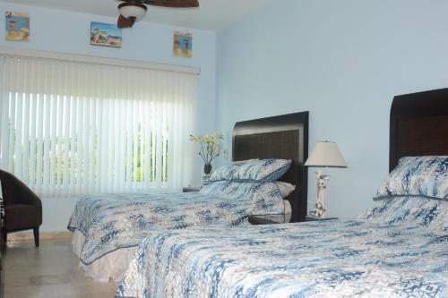 1 dormitorio con 2 camas con sábanas azules y blancas en Hermoso y confortable departamento., en Ixtapa