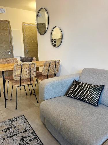 un salon avec un canapé, une table et des miroirs dans l'établissement Appartement 1 chambre Monte Stella, à Monticello