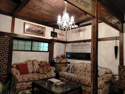 a living room with two couches and a chandelier at CASA DE YOSHi 一棟貸し in Yamagata