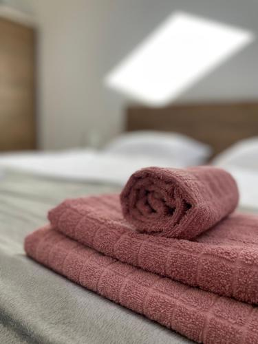 - une serviette rose assise au-dessus du lit dans l'établissement Mills, Stari Grad - Baščaršija, à Sarajevo
