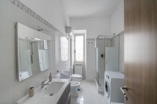 a white bathroom with a sink and a toilet at Casa ilaria in Ladispoli