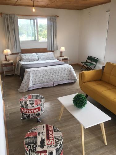 un dormitorio con una cama y un sofá en Mainumby, en Punta del Diablo