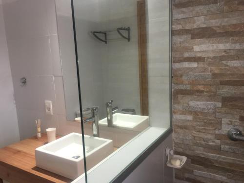 Un baño con lavabo y ducha de cristal. en Mainumby, en Punta del Diablo