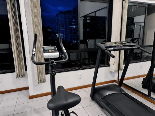a room with a treadmill in front of a window at Hotel Germânia in Joinville