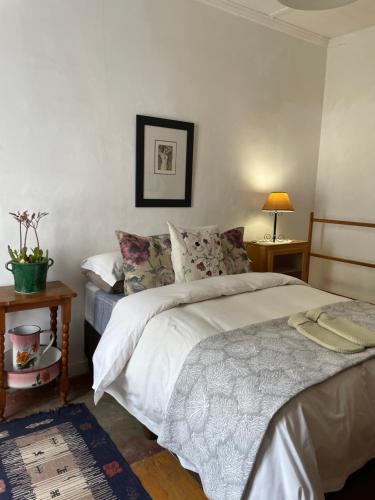 a bedroom with a bed and two tables and a lamp at Laasteskof - The end of the road in Prince Albert