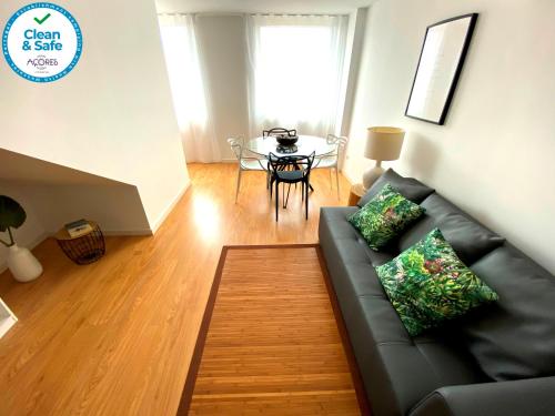 un soggiorno con un divano e un tavolo di Karamba Azores AP central a Ponta Delgada