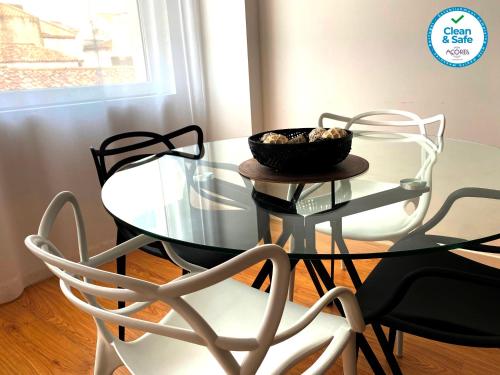 un tavolo di vetro con due sedie e una ciotola sopra di Karamba Azores AP central a Ponta Delgada