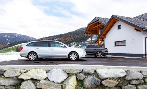 two cars parked in a parking lot next to a building at Das Dorfnest in Sankt Margarethen im Lungau
