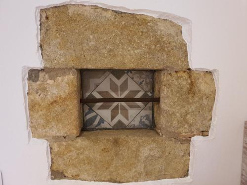 a stone wall with a window in the middle at Can Costals Olivo in Pals
