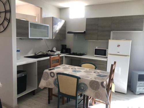 a kitchen with a table with chairs and a refrigerator at T3 Frontignan ville dans un quartier calme in Frontignan