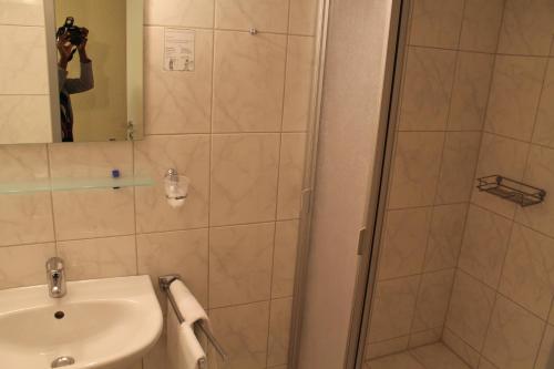 a person taking a picture of a shower in a bathroom at Hotel Harburger Hof in Hamburg