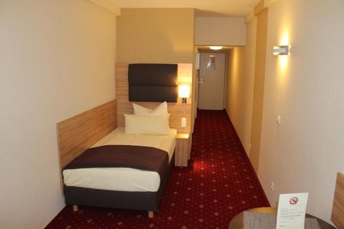 a room with a bed in a hotel room at Hotel Harburger Hof in Hamburg