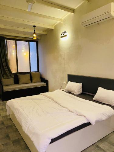 a bedroom with a large bed and a window at Mountain N Lake Resort in Igatpuri
