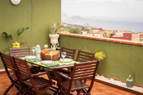 einen Tisch mit Stühlen und einen Obstkorb auf dem Balkon in der Unterkunft Green Sky in San Juan de la Rambla