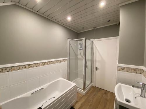 a bathroom with a shower and a tub and a sink at The Durham Terrace in Spennymoor