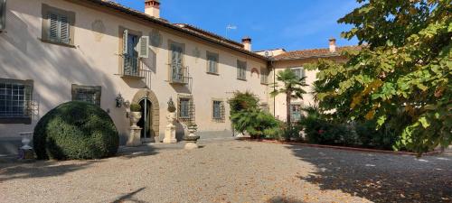 une grande maison blanche avec une allée en face de celle-ci dans l'établissement Agriturismo La Rugea - Le Spighe, à Prato