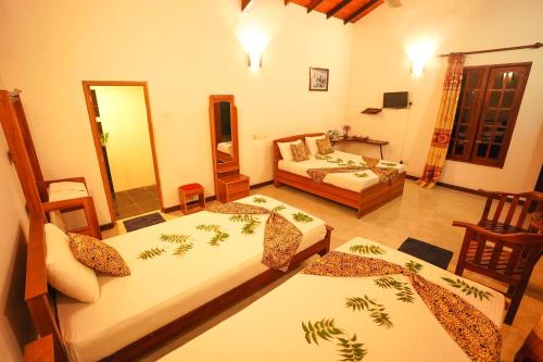 a bedroom with two beds and a living room at Vaana Resort in Habarana