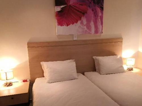 two beds in a hotel room with two lamps at 17 on 13th in Edenvale