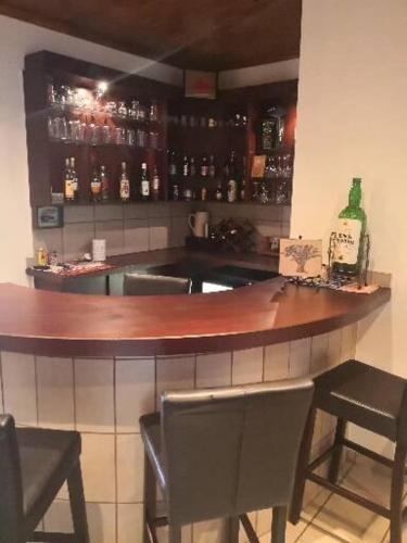 a bar with two chairs and a wooden counter top at 17 on 13th in Edenvale