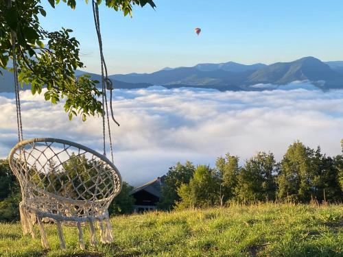 a chair on a hill with a view of clouds at Belle maison Vue imprenable lac de Serre-Ponçon in Prunières