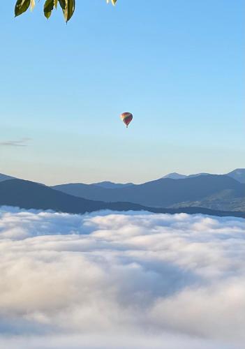 a helicopter flying over a layer of clouds at Belle maison Vue imprenable lac de Serre-Ponçon in Prunières