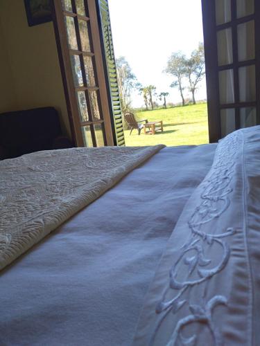 a bed in a room with a view of a field at La Perdida Casa de Campo in San Antonio de Areco