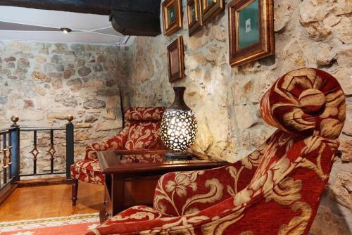 a room with a couch and a table with a vase at Hotel Casa del Marqués in Santillana del Mar