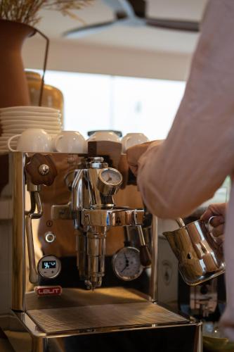 a person is standing next to a coffee machine at Khan Ein Karem Boutique Hotel in Jerusalem